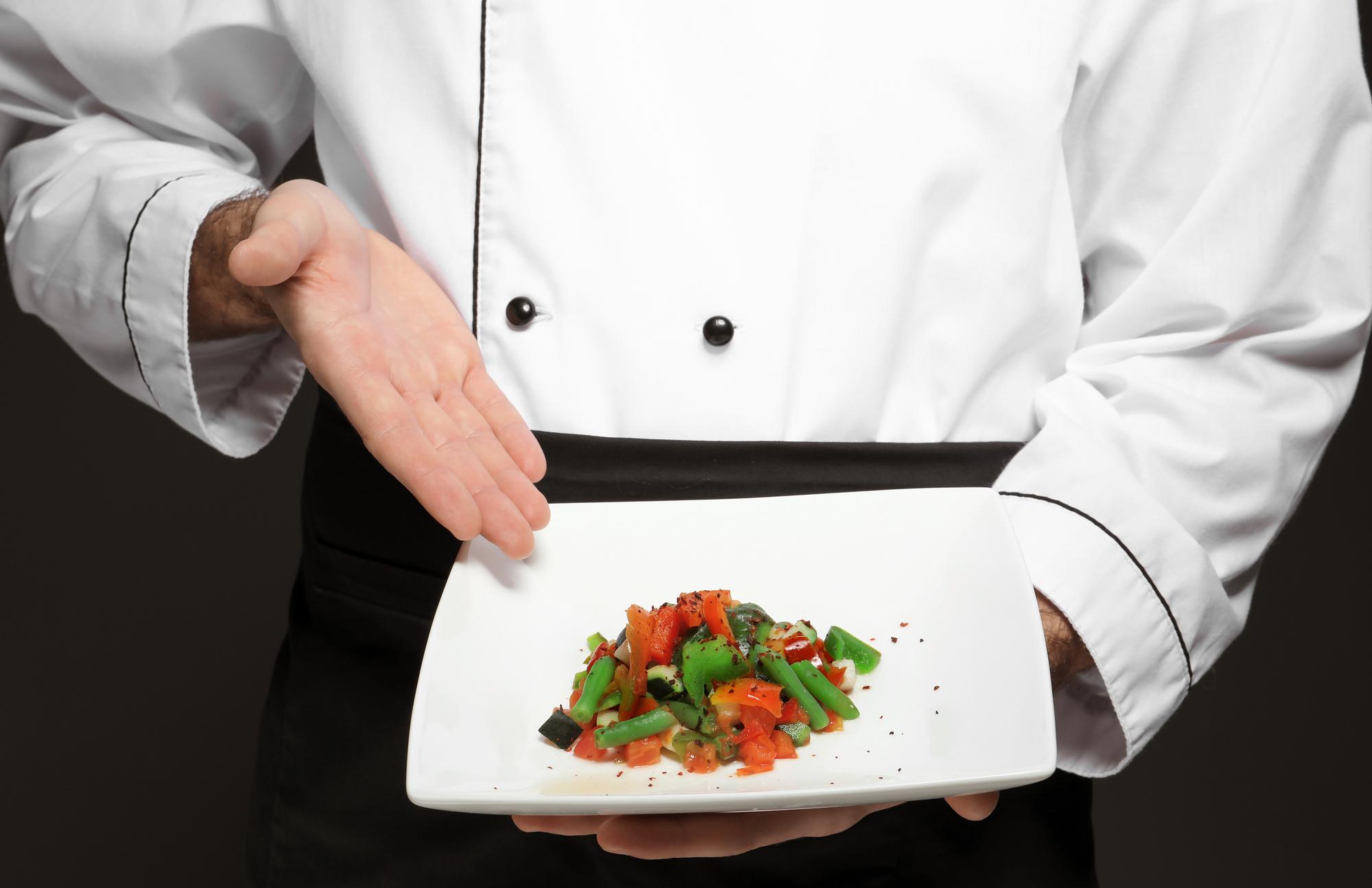 Chef preparing plated dish in modern kitchen